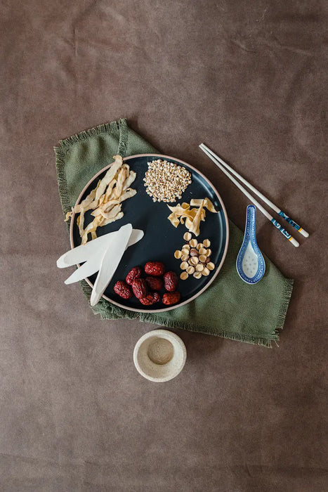 Dishes with Chinese herbs items on a brown textured surface