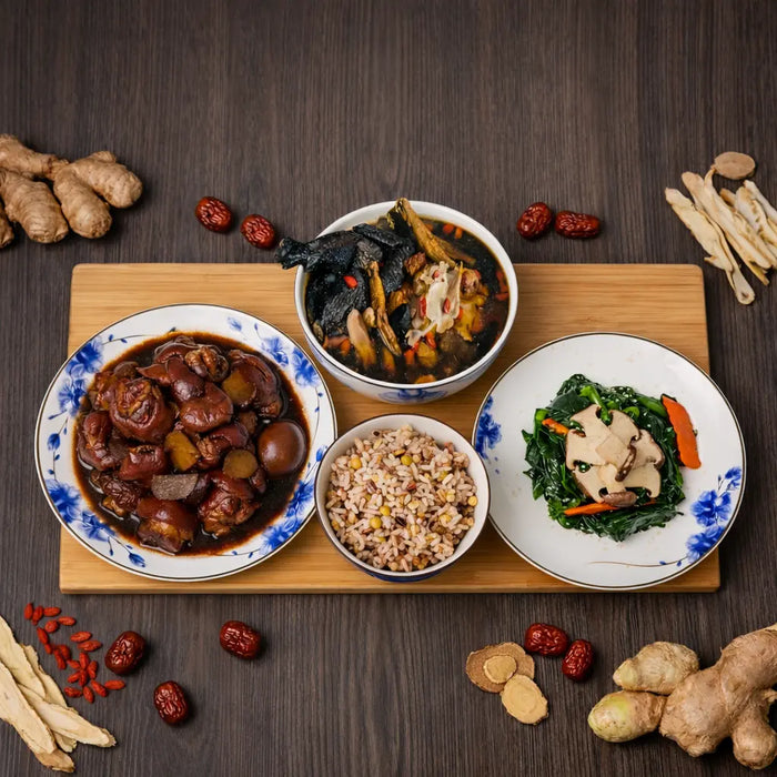 Assorted Chinese dishes on a wooden board with ingredients on a dark surface