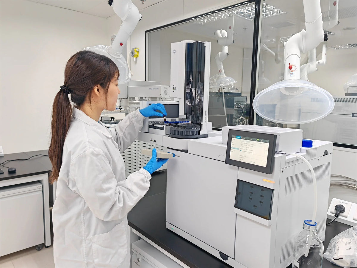 Lab analyst loading herb samples into a testing instrument